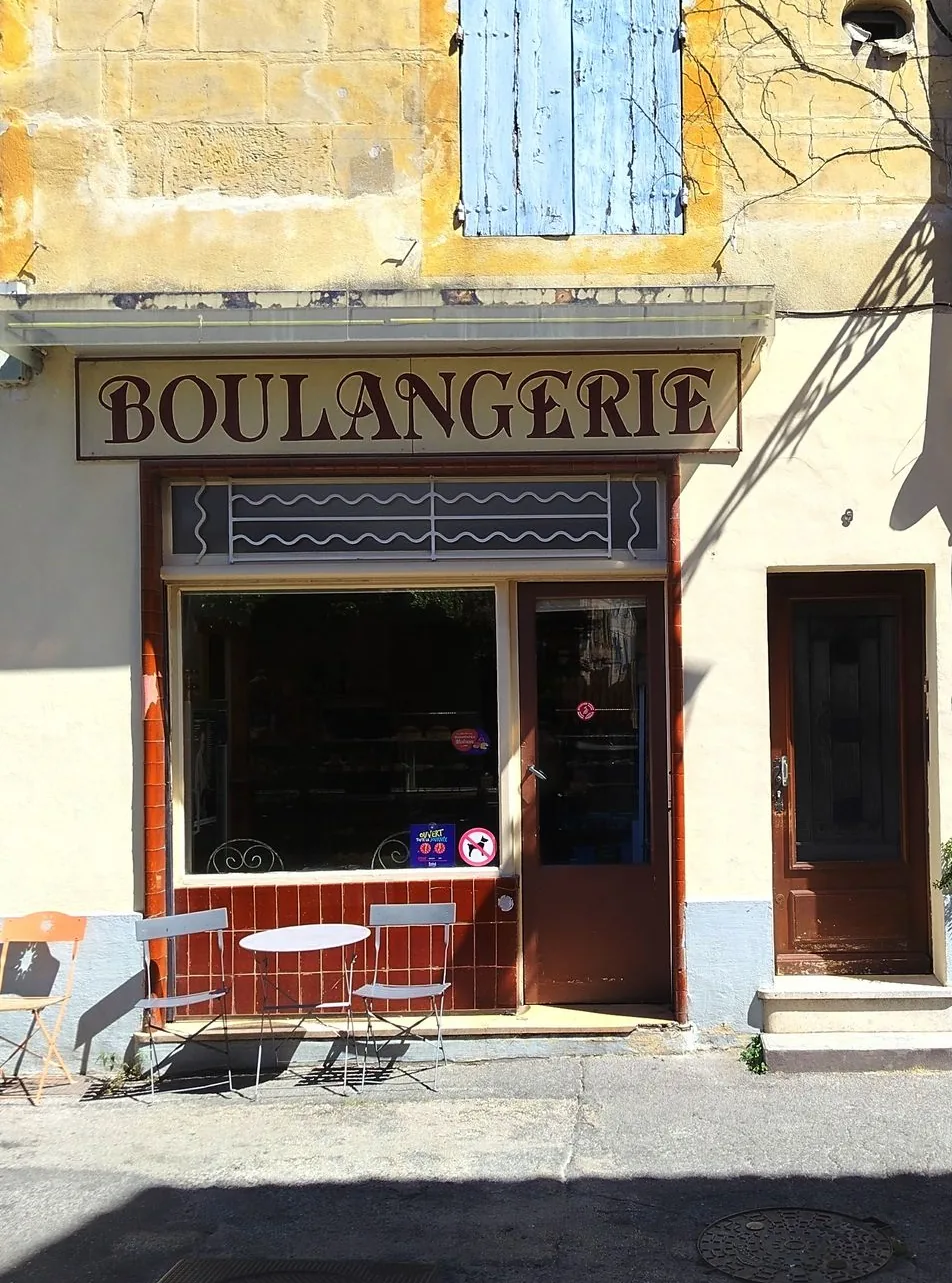Boulangerie de village en Provence avec façade ocre et volets bleus