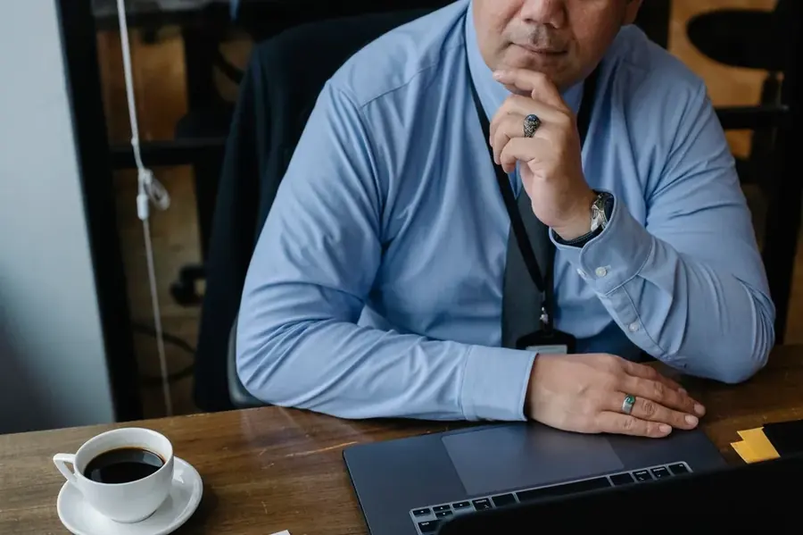 Business owner thinking in front of a laptop while taking stock of their website