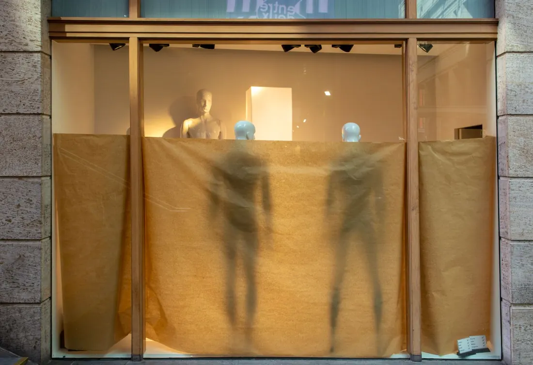 Vitrine recouverte de papier kraft, mannequins en transparence